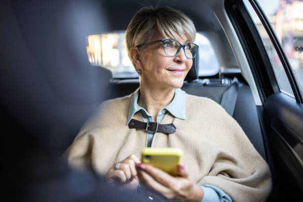 Frau mit Smartphone auf der Rückbank