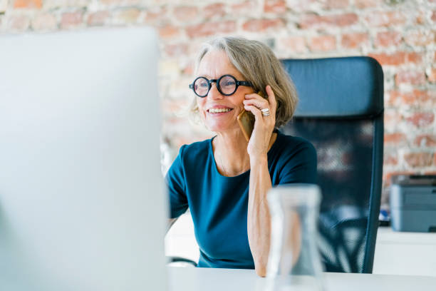 Frau telefoniert am Schreibtisch